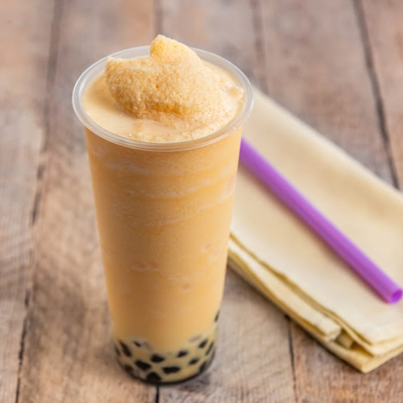 A Happy Pho Teriyaki Vietnamese bubble tea with tapioca pearls and a purple straw.