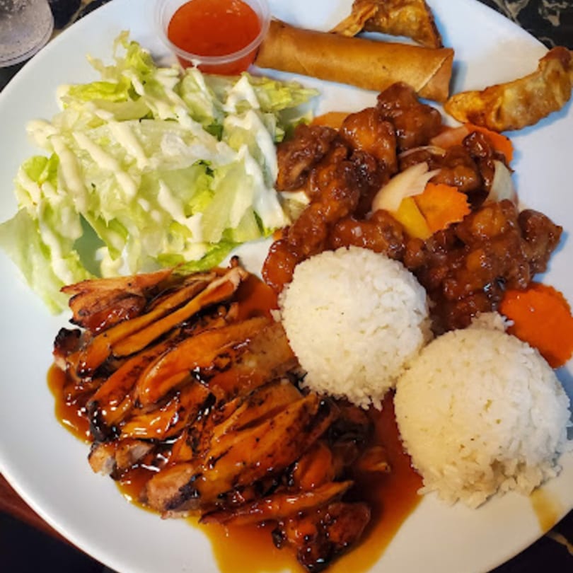 Happy Pho Teriyaki plate with chicken, sweet and sour chicken, rice, salad, egg roll, and dumplings.